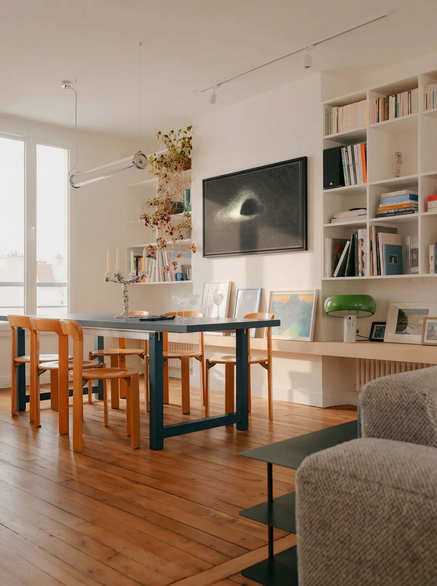 Interior of a modern dining room featuring artwork titled Black Hole, 1979, on the wall.